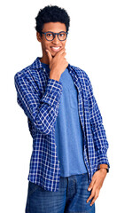 Young african american man wearing casual clothes and glasses looking confident at the camera smiling with crossed arms and hand raised on chin. thinking positive.
