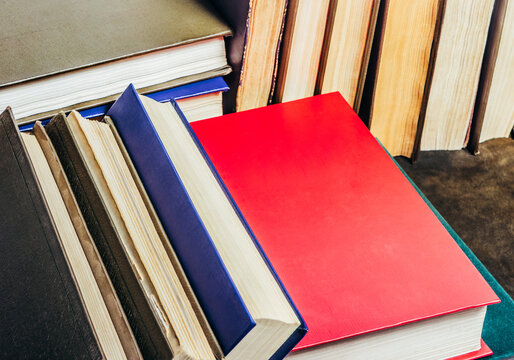 Photo of old antique books laying on leather table surface.