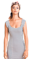 Young beautiful woman wearing king crown with serious expression on face. simple and natural looking at the camera.