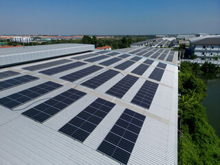 Top aerial view of solar roof system at the rooftop of factory warehouse. renewable energy of photovoltaic for reduce energy and carbon footprint. clean energy. solar panel and structure at building.