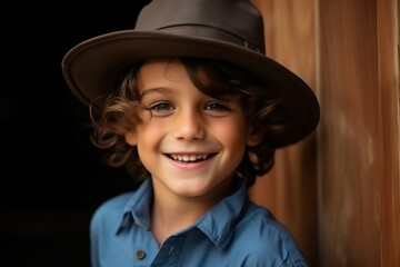Portrait of a cute little boy in a hat on a dark background