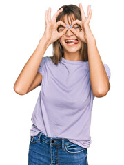 Obraz na płótnie Canvas Teenager caucasian girl wearing casual clothes doing ok gesture like binoculars sticking tongue out, eyes looking through fingers. crazy expression.
