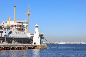 桟橋に係留されている客船と白い灯台
