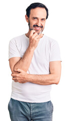 Middle age handsome man wearing casual t-shirt looking confident at the camera smiling with crossed arms and hand raised on chin. thinking positive.