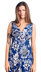 Beautiful caucasian woman wearing summer dress skeptic and nervous, frowning upset because of...