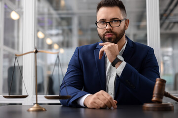 Portrait of handsome lawyer at table in office