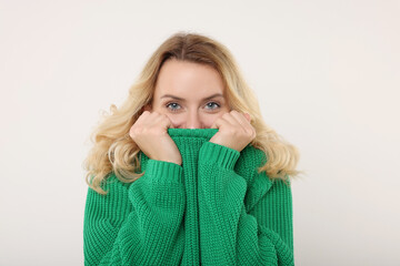 Beautiful woman in stylish warm sweater on white background