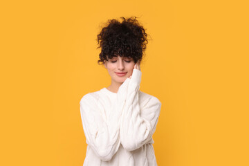 Young woman in stylish white sweater on yellow background