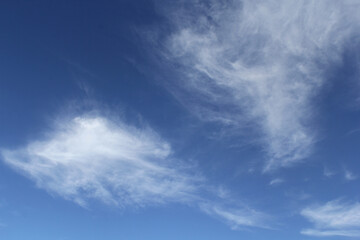 Naklejka na ściany i meble Wispy white clouds cloudscape in a blue sky