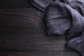 Felting wool on wooden table, top view. Space for text