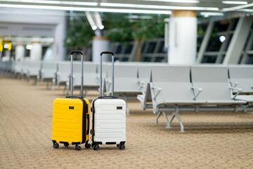 Two suitcases in an empty airport hall, traveler cases in the departure airport terminal waiting for the area, vacation concept, blank space for text message or design