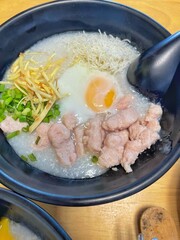 boiled rice clear soup with shrimp in a ceramic bowl on wooden table. homemade style food concept.