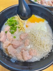 boiled rice clear soup with shrimp in a ceramic bowl on wooden table. homemade style food concept.