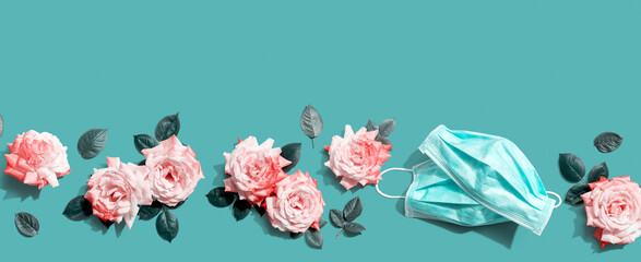 Face masks with pink roses overhead view - flat lay