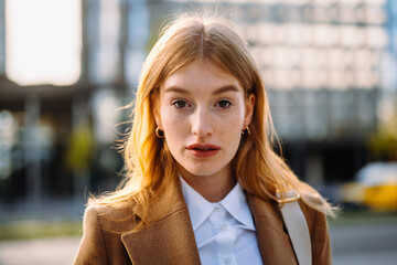 Portrait gorgeous realtor strolling street and looking camera