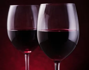Fotobehang Red wine in a glass on a dark red and black background. two glasses for wine. A romantic drink for a party, liquor store or wine tasting. Copy space © Pink Zebra