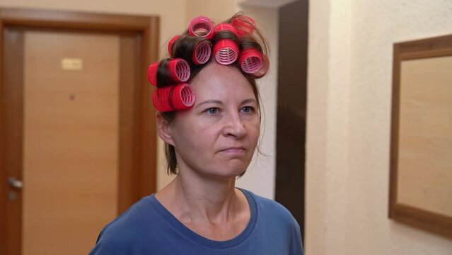 Dissatisfied woman with curlers on head, angry old maid neighbor, landlord is dissatisfied with noise, puts finger to mouth, demands silence, barely restrains negative emotions, leaves shaking head