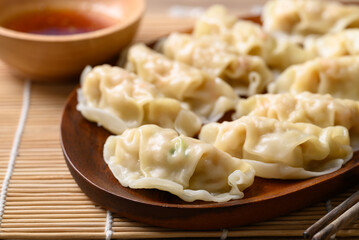 Steamed wonton dumpling stuffed with minced pork and chicken eating with sesame oil sauce