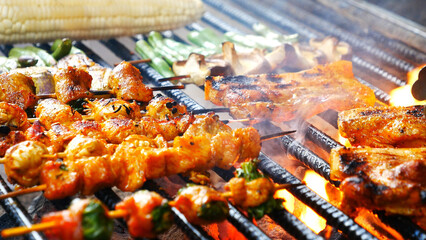 BBQ Barbecue grilled meat stick on fire flame with hot charcoal cooking outside. Beef grilling picnic outdoor with smoke bacon spicy sausage for party. Grill pork bbq on fire flame