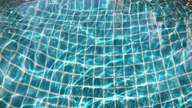 ripple on the surface of transparent blue water in swimming pool, close up 4K motion scene