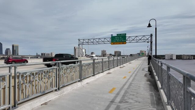 Traffic passing by on the Fuller Warren Bridge with downtown Jacksonville in the background.