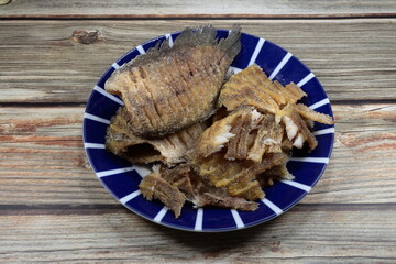 Pile of deep fried gourami fish (Snake skin fish) serving on the plate. Famous appetizer seafood...