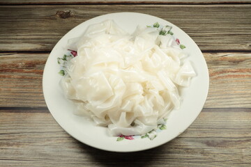 Chinese steamed rice. Pile of fresh and organic rice noodle on the plate. Famous carbohydrate ingredient in Asian kitchen.