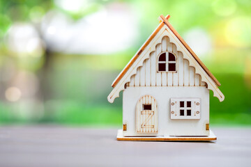 Obraz na płótnie Canvas House model with green bokeh on background. Background for Home buying checklist, Hire a Real Estate, Refinance, Home loan, Tax, Mortgage loan, Asset management and Property investment concept.