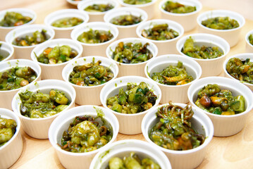 Pesto Coated Seafood in White Ramekins. Numerous white ceramic ramekins filled with seafood tossed...