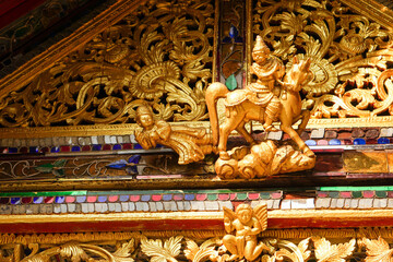 Closeup and crop antique golden carved wood Burmese art on the roof of the Burmese temple chapel in...