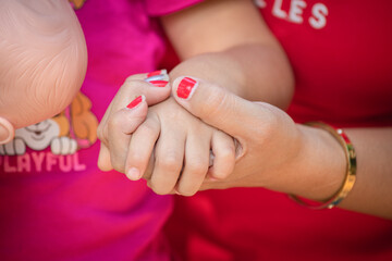 Little kid holding family member mother hand as a together family