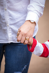 Little kid holding family member mother hand as a together family