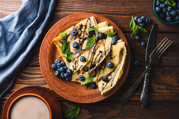 Pancakes with blueberries, chocolate sauce and mint