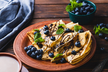 Pancakes with blueberries, chocolate sauce and mint
