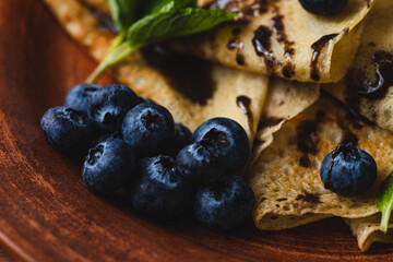 Pancakes with blueberries, chocolate sauce and mint