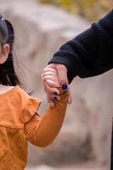 Little kid holding family member mother hand as a together family