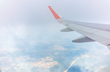 Obraz premium View from the airplane window during taking off on a clear summer morning