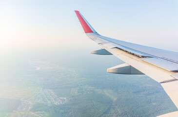 Obraz premium View from the airplane window at a beautiful cloudy sky and the airplane wing