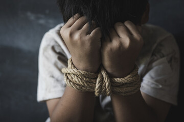 Victim boy with hands tied up with rope in emotional stress and pain,  kidnapped, abused, hostage,  afraid, restricted,  Stop violence against children and trafficking Concept. - obrazy, fototapety, plakaty