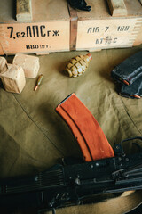 The militaristic background. an a1 grenade and a box of cartridges and a Kalashnikov assault rifle....