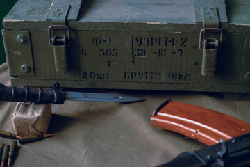 Military background, Kalashnikov assault rifle, f-1 grenades, bayonet knife and cartridges. Closeup