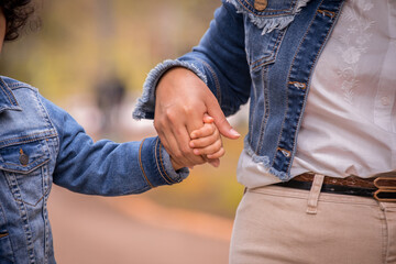 Little kid holding family member mother hand as a together family