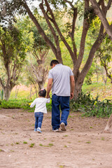 Family members holding hands and walking backwards in a park together family