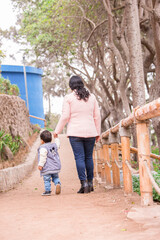 Family members holding hands and walking backwards in a park together family