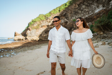 husband and wife asia in white hold hands while walking to enjoy vacation with copyspace