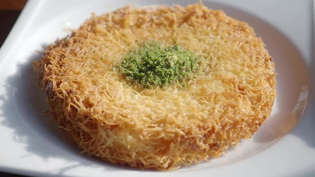 kunafa with a wipe cream on a plate .