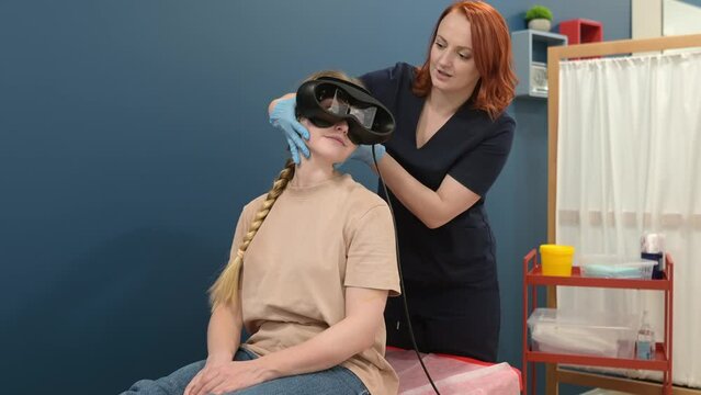 Woman with vertigo symptoms is on appointment of neurologist. Doctor making positional testing of patient with using VNG for determine type of dizziness and performing Epley maneuver
