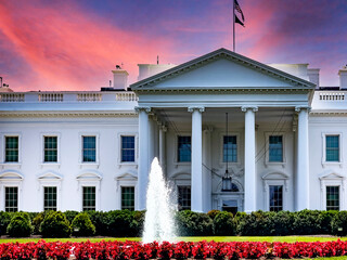 The white house located in the American capital of Washington DC, under a reddish-orange sky at...