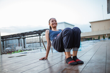 Woman doing prepare of glute bridge exercise or pithasana pose by balcony hotel