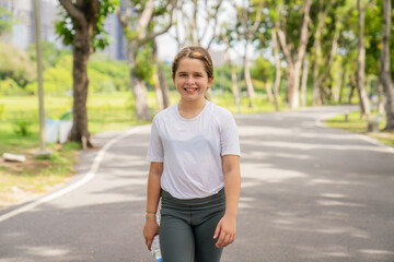 Cute little girl playing and jogging at the city park. Have fun and enjoy living outdoors during the summer holidays.